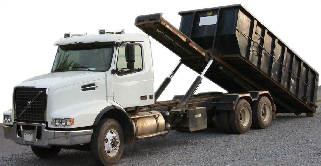 Roll-off dumpster being unloaded from a truck